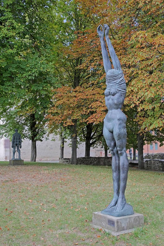 Sculpture Große Neeberger Figur von Wieland Förster 1997, nude standing female figure, nude, undress, undressing, clothes, over, head, covered, up, without, arms, high, up, stretching, bronze sculpture, modern art, sculpture park, Magdeburg, Saxony-Anhalt, Germany