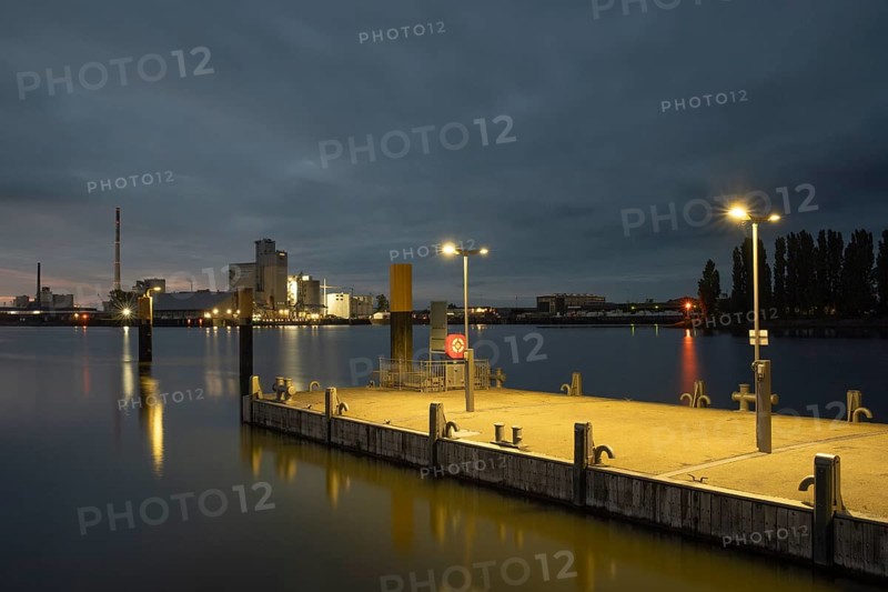 View of a mooring pontoon on the Weser at Lankenauer Höf in the background an industrial area in the evening light, Gröpelingen, Bremen, Germany