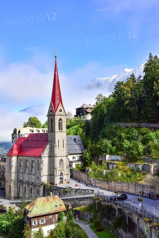 Parish church on the waterfall path in Bad Gastein, in the background the snow-covered peaks of the mountains of the Ankogel group in the province of Salzburg, Austria
