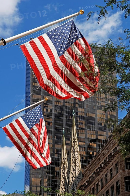 Waving USA flags, behind towers of St Patrick's Cathedral, Manhattan, New York City, USA