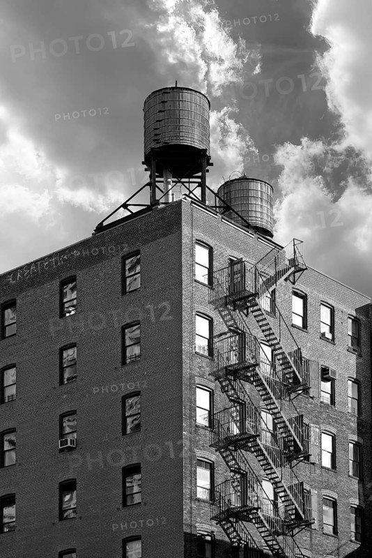High-rise residential building with wooden water tanks on the roof, black and white, New York City, USA