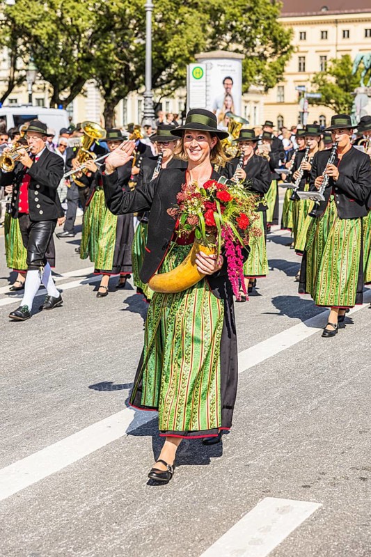 Marketender with flower-decorated cornucopia in front of the brass band from Aschheim, traditional traditional costume and rifle parade, Oktoberfest, Munich, Upper Bavaria, Bavaria, Germany