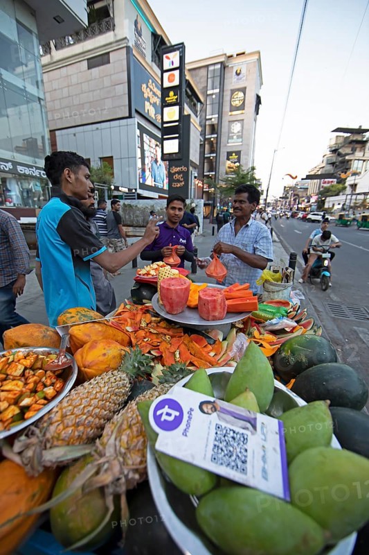 Indian men buying fresh fruit at a roadside stall, Begaluru or Bangalore, Karnataka, India