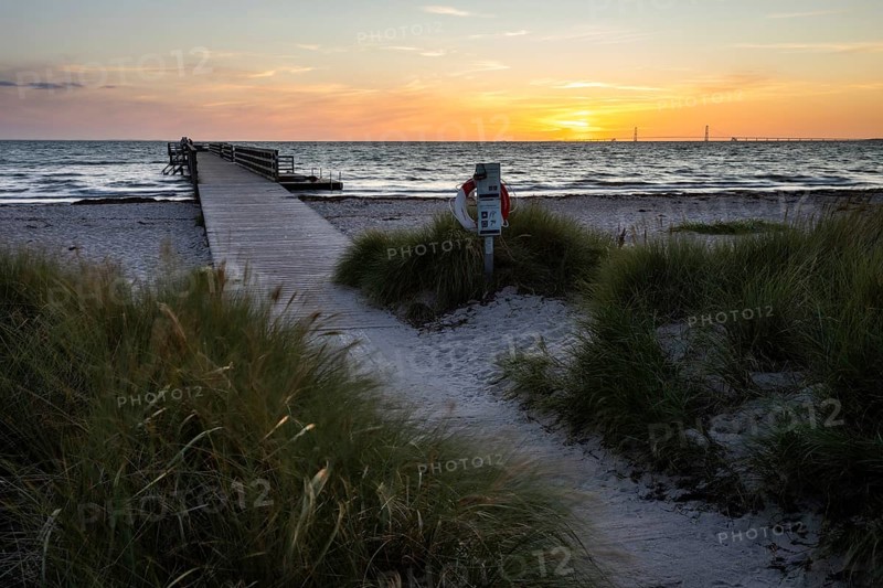 Evening beach dunes and lonely passenger pier at sunset, peaceful sea waves, Kobaek Strand, Sjaelland, Denmark