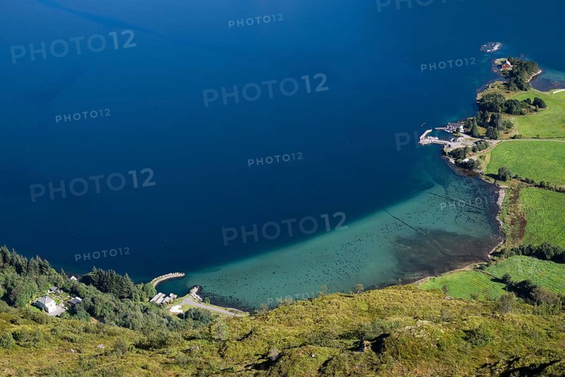 Coastal landscape with clear blue water and green meadows, houses, Otroya or Otrøya island, Møre og Romsdal, Norway