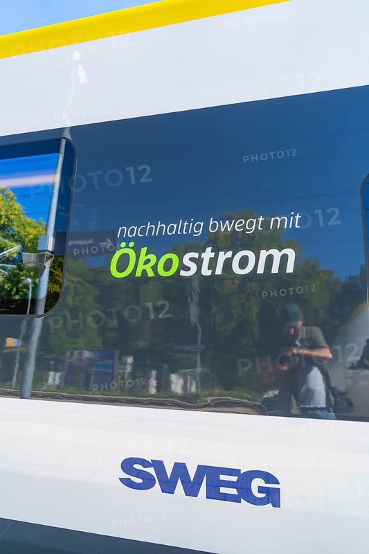 Train with sustainable ecological advertising and reflections on the window, battery Electric train with green electricity, Siemens Mireo Plus B, Freudenstadt, Germany