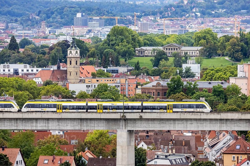 SWEG regional train travelling on the Schusterbahn, Münster viaduct with Bad Cannstatt and Rosensteinpark, Rosenstein Castle. Stuttgart, Baden-Württemberg, Germany