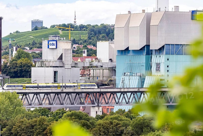 SWEG regional train travelling on the Schusterbahn, Münster viaduct with EnBW Energie Baden-Württemberg combined heat and power plant. Stuttgart, Baden-Württemberg, Germany