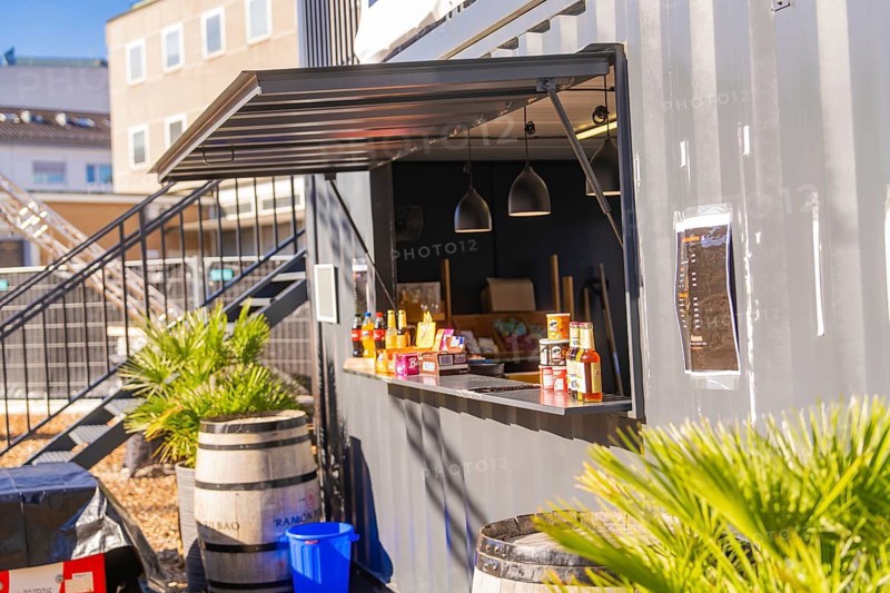 Close-up view of a snack bar in a container with barrels and plants, open-air cinema Sindelfingen, district of böblingen, Germany