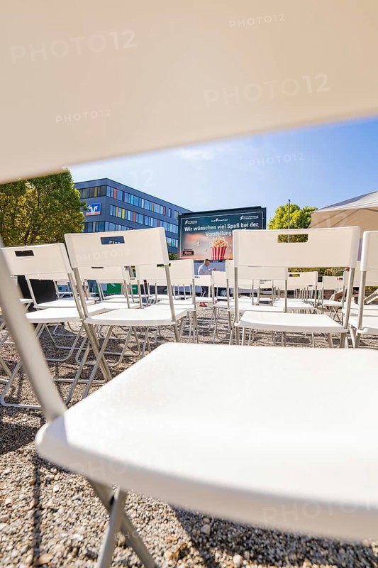 Rows of white chairs in front of an outdoor screen on a sunny day, open air cinema Sindelfingen, district of böblingen, Germany