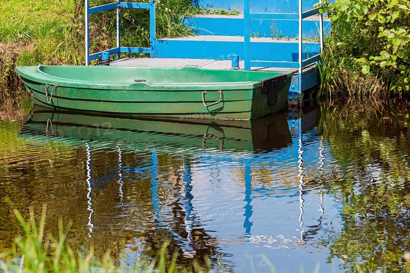 Green boat anchored in front of a blue staircase, Lower Saxony, Germany