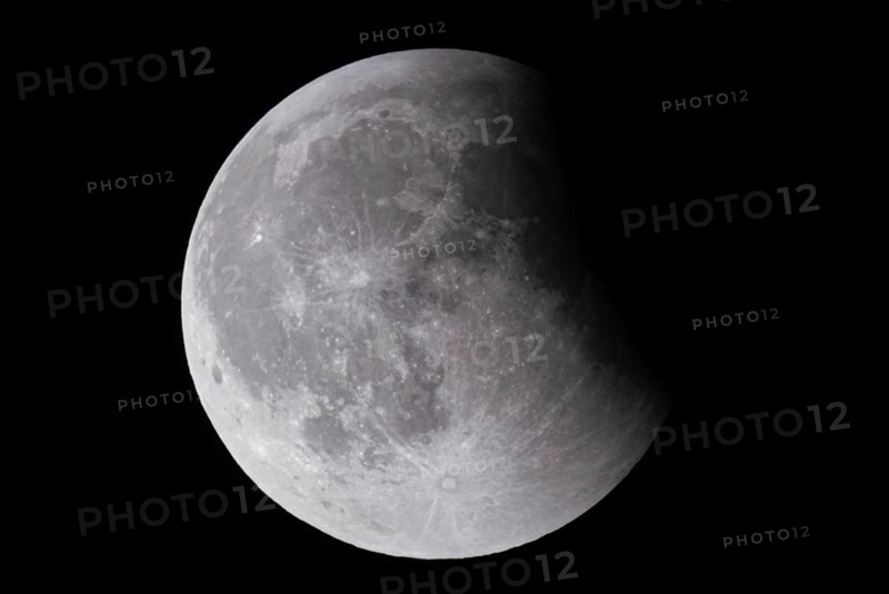 After a total lunar eclipse, the moon appears shortly after its rise in the evening sky as a so-called blood moon in front of it then begins to emerge from the Earth's umbra, Frankfurt am Main, Hesse, Germany