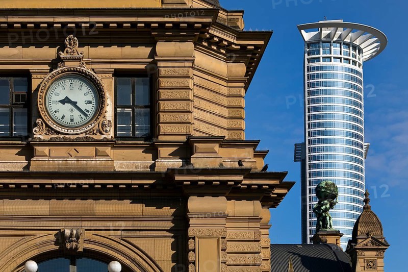 Side front of the main railway station with Atlas carrying the globe on his shoulders in front of the DZ Bank tower block, Frankfurt am Main, Hesse, Germany