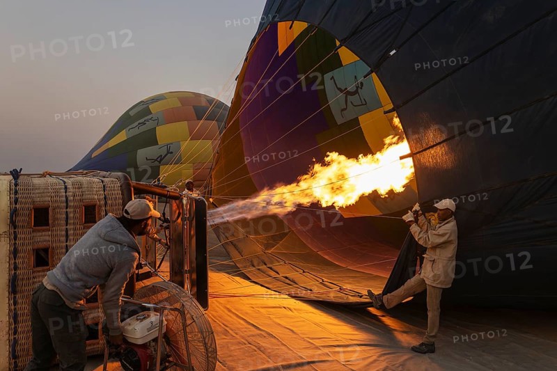 In order to get ready for the take-off, the pilot inflates the balloon with hot air by activating the burner. At dawn. Namib Desert, Kulala Wilderness Reserve, Namibia