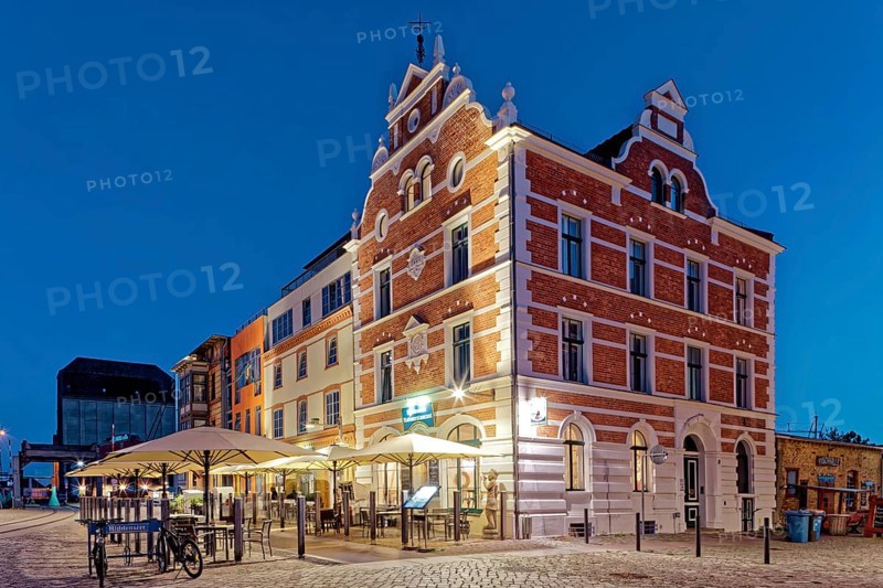 Night shot, magnificent building with outdoor seating and sunshade, built in 1889, Hiddenseer Hafenrestaurant und Hotel, Hafenstraße 12B, harbour island, old town, UNESCO World Heritage Site, Hanseatic City of Stralsund, Mecklenburg-Western Pomerania, Germany