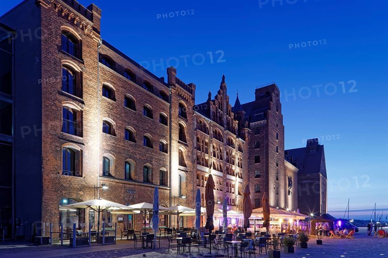 Night shot, outdoor seating, sunshades, restaurant, illuminated, romantic scenery behind, building, brick warehouse, harbour street, harbour island, old town, UNESCO World Heritage Site, Hanseatic city of Stralsund, Mecklenburg-Western Pomerania, Germany