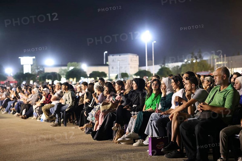 Audience members enjoy a musical performance during the Damascus International Fair in Damascus, Syria, attended by local citizens and international guests, Damascus, Damascus, Syria