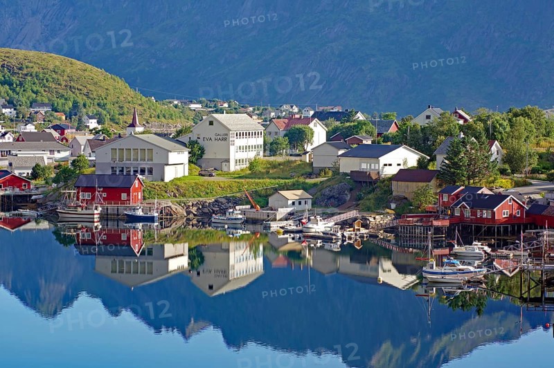 Small village with colourful houses and harbour facilities, picturesquely situated on the water, reflections, Reine, Reinefjord, Lofoten, Moskenes, Nordland, Norway