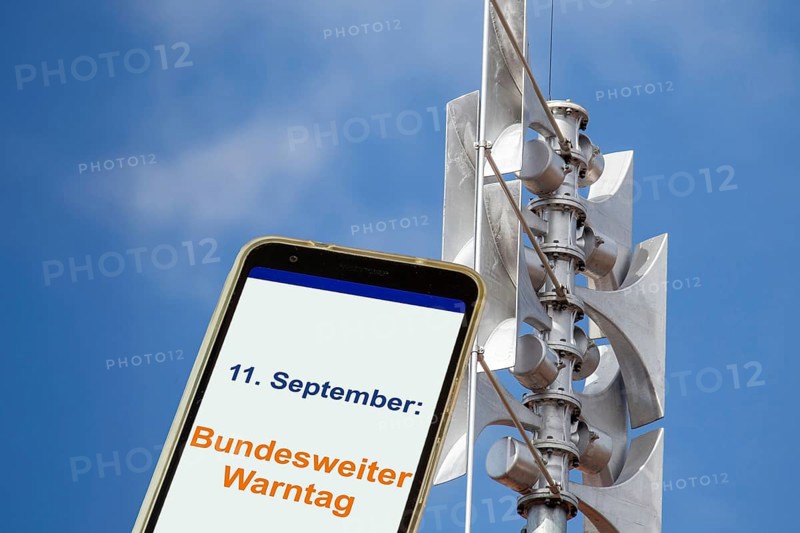 (Photomontage) Close-up of a siren, next to it an open smartphone with text 11 SEPTEMBER: FEDERAL WARNING DAY