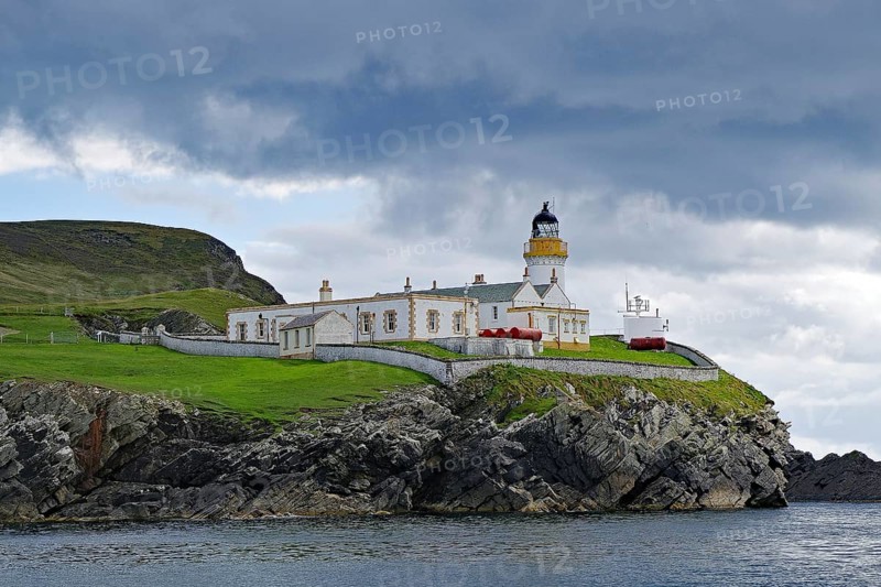 A lighthouse stands on a grassy cliff on a cloudy day, Robert Louis Stevensen, Isle of Noss, Shetland Islands, Scotland, Great Britain