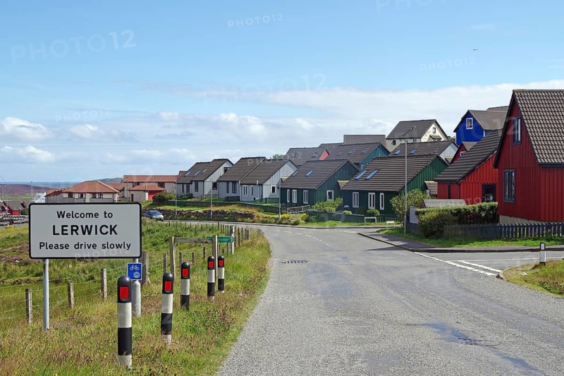 Colourful houses line a street with a welcome sign in a town, Lerwick, Shetland Islands, Scotland, United Kingdom