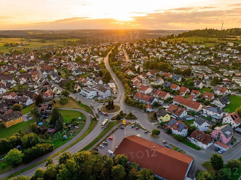 Sea of houses with curved streets in warm sunset light and green surroundings, small town of Perle Calw, Black Forest, Germany
