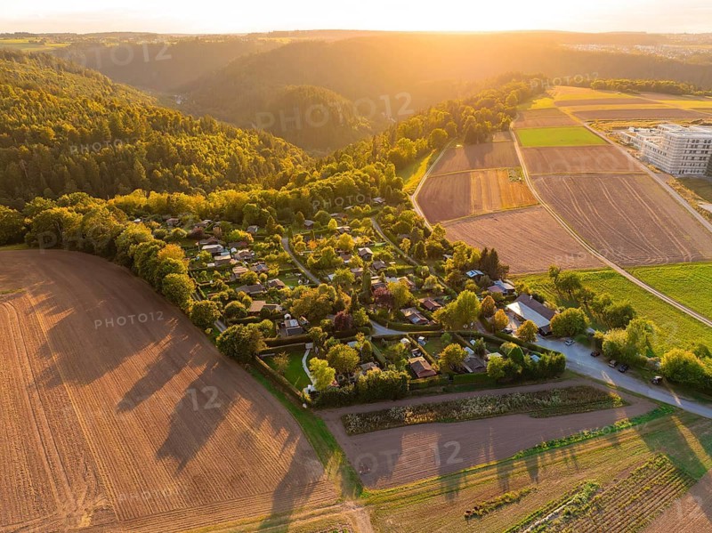 Campsite between forests and fields at sunset with rolling hills, small town Perle Calw, Black Forest, Germany