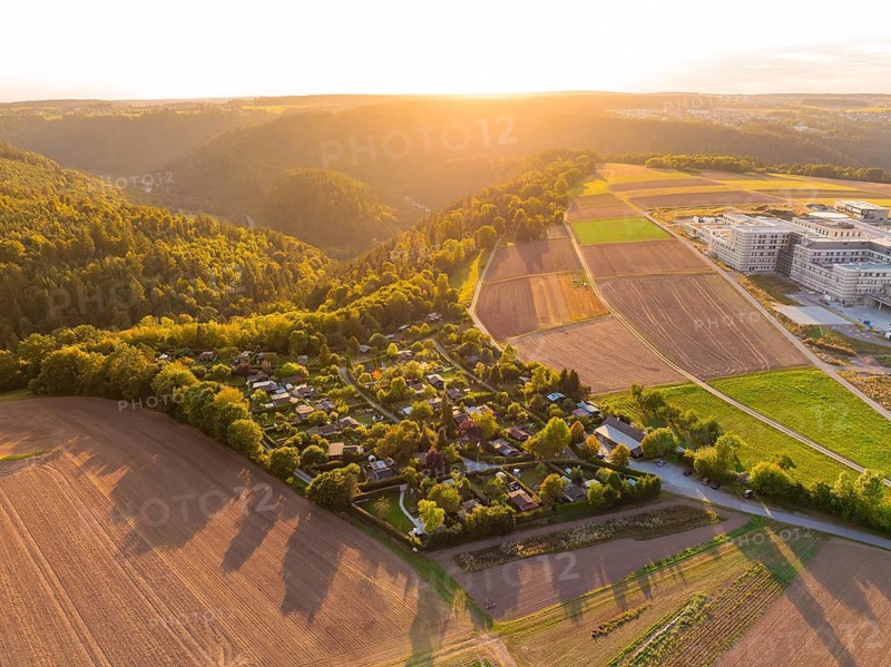 Campsite on the edge of a forest with farmland in the warm light of the setting sun, small town of Perle Calw, Black Forest, Germany