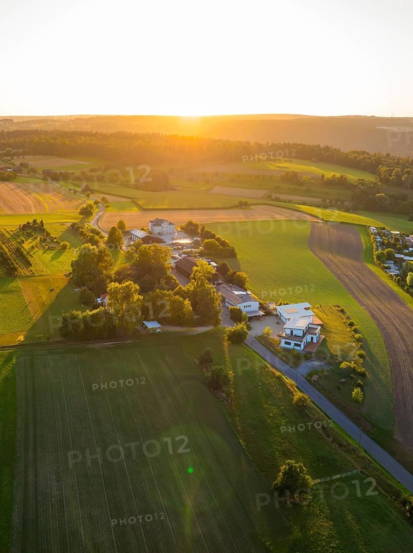 Idyllic landscape with fields and buildings in the warm light of the sunset, small town of Perle Calw, Black Forest, Germany