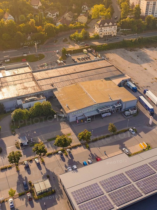 Industrial buildings at dusk with solar panels on the roof and car parks, small town of Perle Nagold, Black Forest, Germany