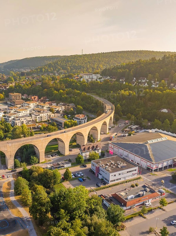 Imposing viaduct over a town with surrounding hills and forest at dusk, small town Perle Nagold, Black Forest, Germany