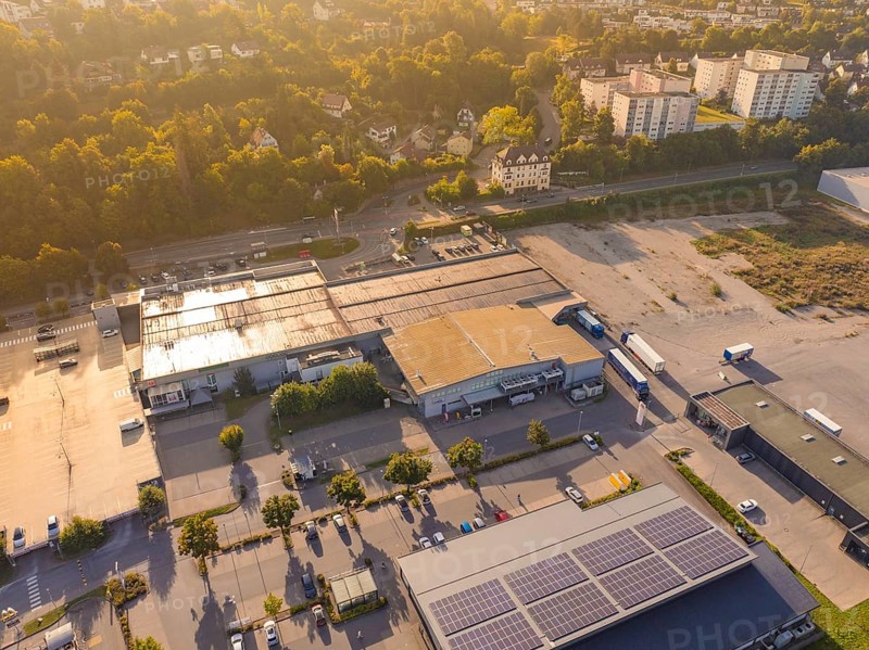 Wide view of an industrial area with car parks and solar panels on the roofs, small town of Perle Nagold, Black Forest, Germany