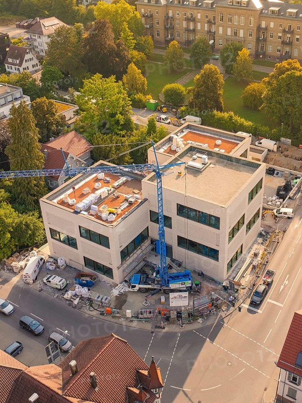Large modern building under construction with a crane surrounded by an urban environment, small town of Perle Nagold, Black Forest, Germany