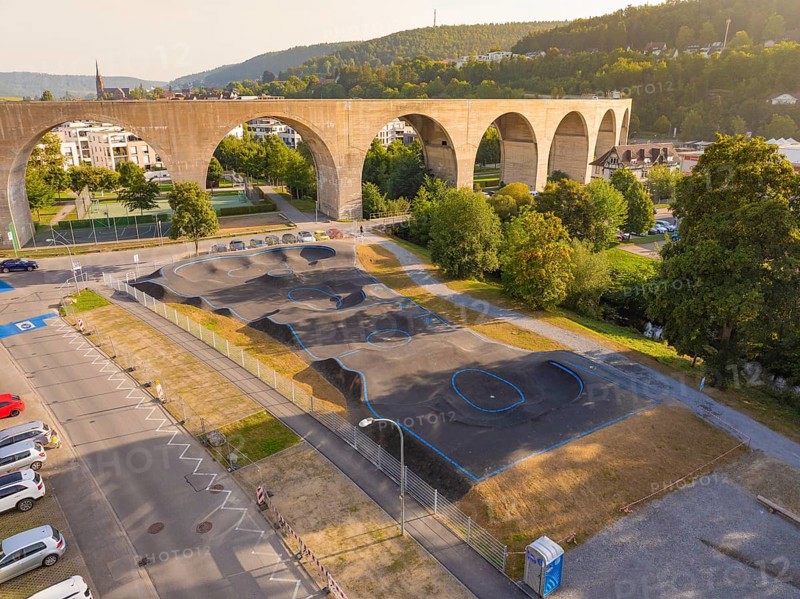 Pump track under a large bridge, surrounded by nature and urban architecture, pump track, Nagold, Black Forest, Germany