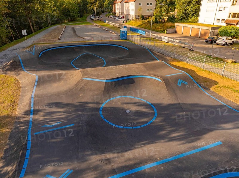 A pump track marked with blue lines in a green, urban environment, pump track, Nagold, Black Forest, Germany