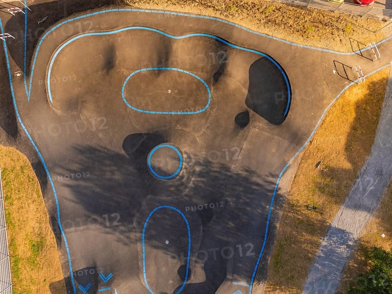 Pump track with blue lines seen from the air, surrounded by shadows and asphalt, pump track, Nagold, Black Forest, Germany
