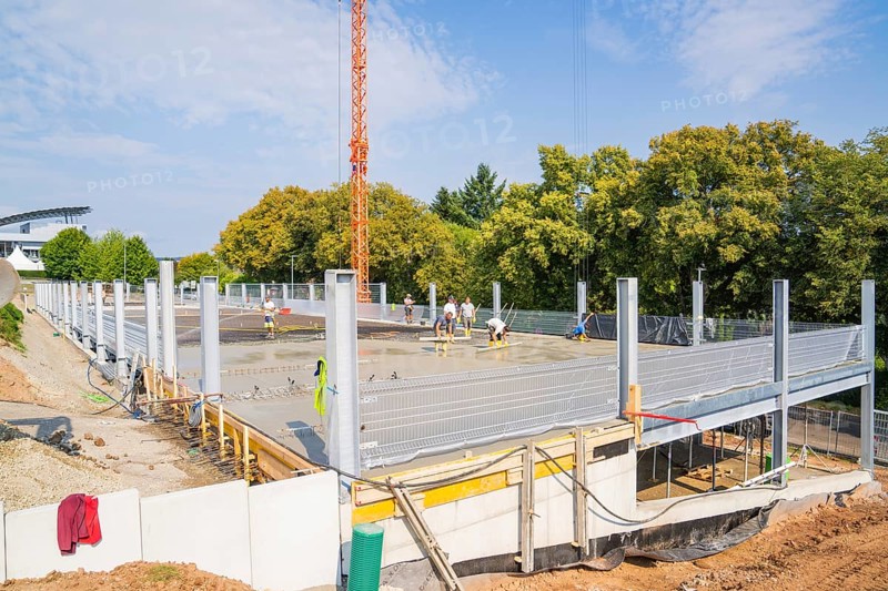 Construction site with metal structures and concrete foundation surrounded by autumnal trees, car park construction, Calw, Germany