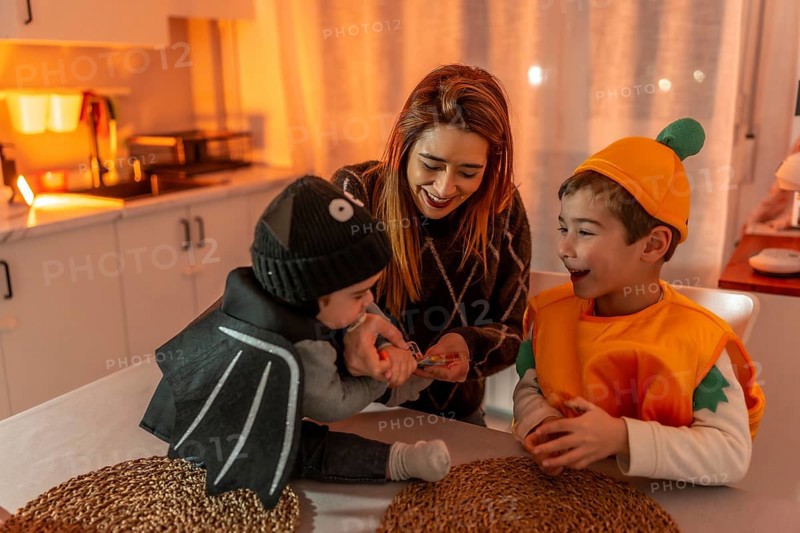 Happy family dressed in festive halloween costumes, joyfully preparing for a fun party at home, creating cherished memories together