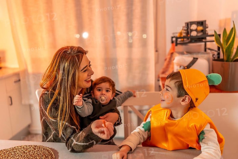 Happy family celebrating halloween together at home, wearing costumes and smiling, enjoying quality time
