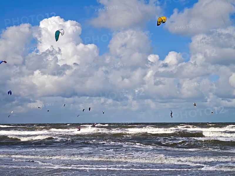 California kitesurfing Masters 2025 on the edge of the UNESCO World Heritage Wadden Sea, North Sea, kitesurfing sport, flying kites, fun, competition, strong wind, high swell, whitecaps, beach, summer, sunshine, blue sky, white clouds, Ording, Sankt Peter-Ording, Schleswig-Holstein, Germany