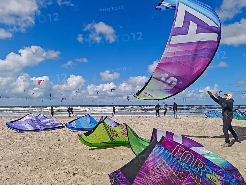 California kitesurfing Masters 2025, kite catching, kitesurfing on the North Sea beach on the edge of the UNESCO World Heritage Wadden Sea, sports competition, strong wind, high swell, whitecaps, summer, sun, blue sky, white clouds, Ording, Sankt Peter-Ording, Schleswig-Holstein, Germany