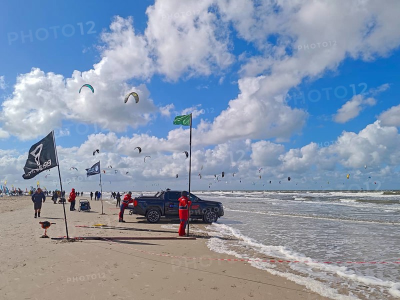 California kitesurfing Masters 2025, kitesurfing on the North Sea beach on the edge of the UNESCO World Heritage Wadden Sea, sports competition, car, flags, strong wind, high swell, whitecaps, summer, sun, blue sky, white clouds, Ording, Sankt Peter-Ording, Schleswig-Holstein, Germany