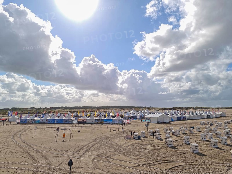 California kitesurfing Masters 2025, tents of the Kite Village with kite equipment for sale, marketplace, try out, kitesurfing on the North Sea beach, blue sky, sun, summer, backlight, Ording, Sankt Peter-Ording, Schleswig-Holstein, Germany