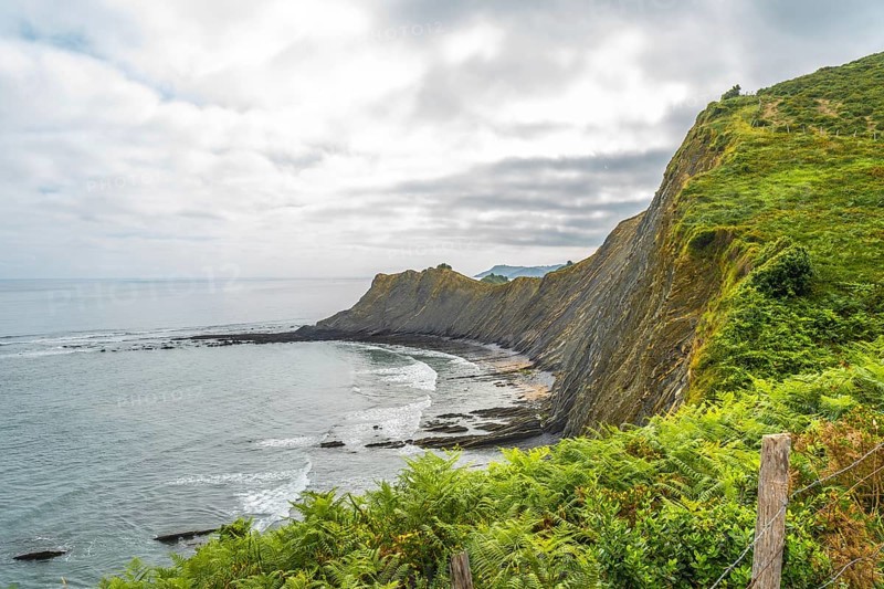 Breathtaking view of the flysch cliffs meeting the ocean waves at sakoneta beach in zumaia, a geological wonder in the basque country