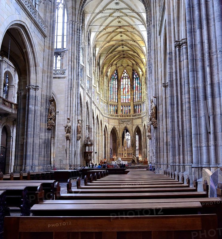 Tourists admiring the stained glass windows and gothic architecture of st. Vitus cathedral in prague castle, czech republic