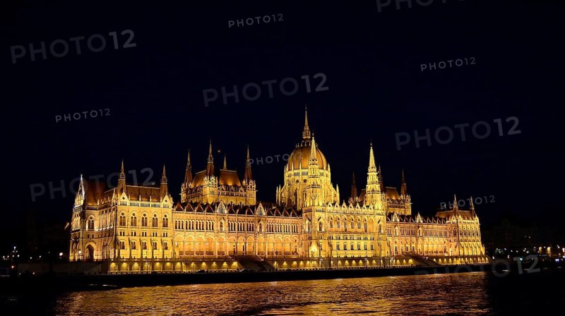 Golden lights highlighting the hungarian parliament building in budapest on the danube river at night