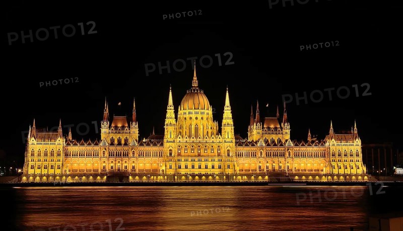 Majestic hungarian parliament building glowing gold at night, reflected in the danube river, budapest, hungary