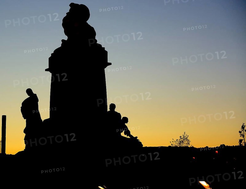 Majestic silhouette of a statue in prague, czech republic, standing tall against the backdrop of a vibrant sunset sky