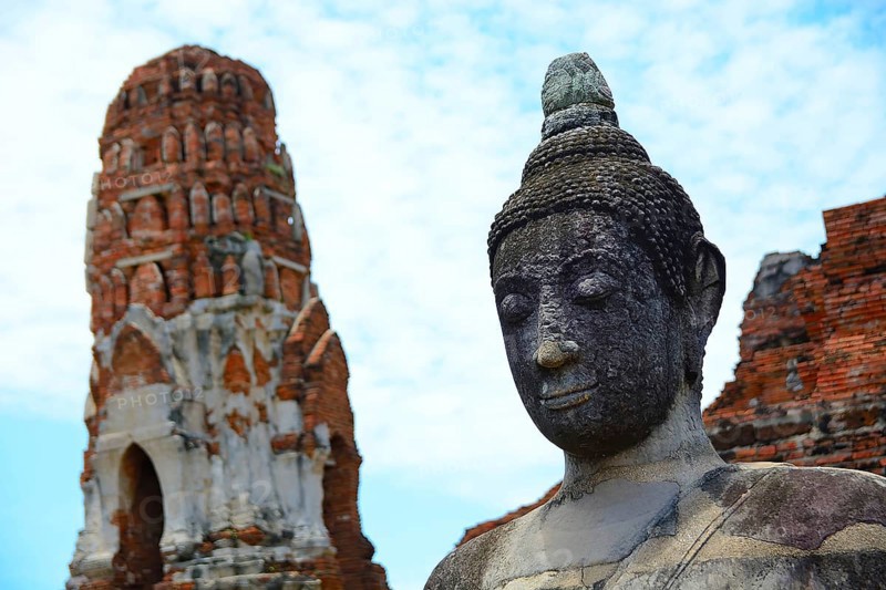 Serene buddha statue stands tall amidst ancient temple ruins, capturing the spiritual essence of ayutthaya's historical heritage