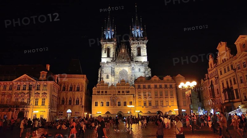 Tourists walking and enjoying old town square and church of our lady before tyn in prague at night